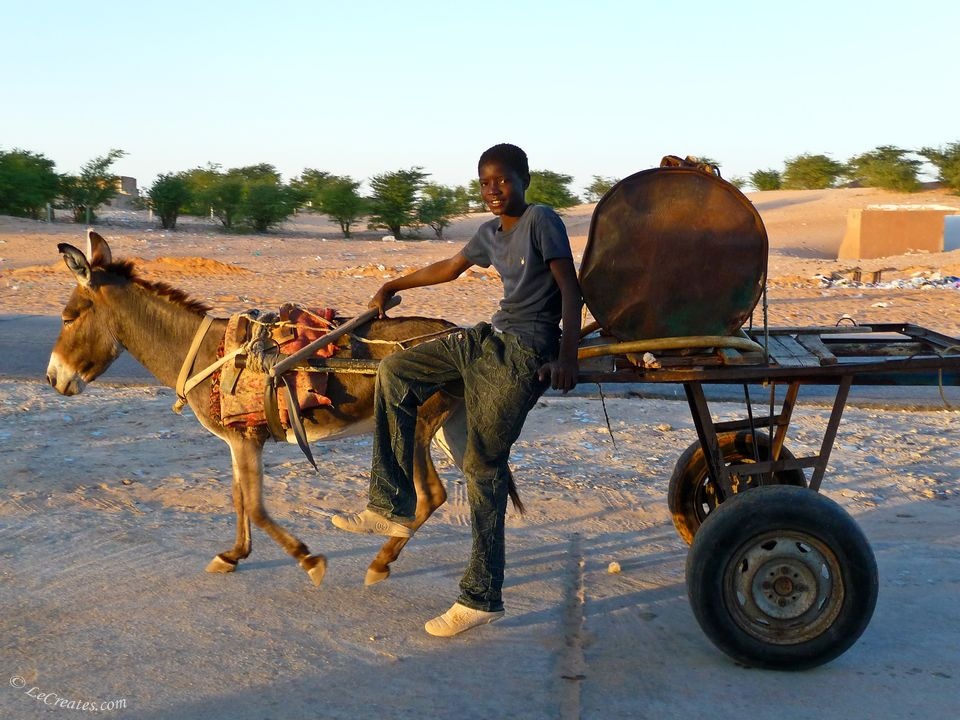 Мавританский мальчишка перевозит бочку с водой